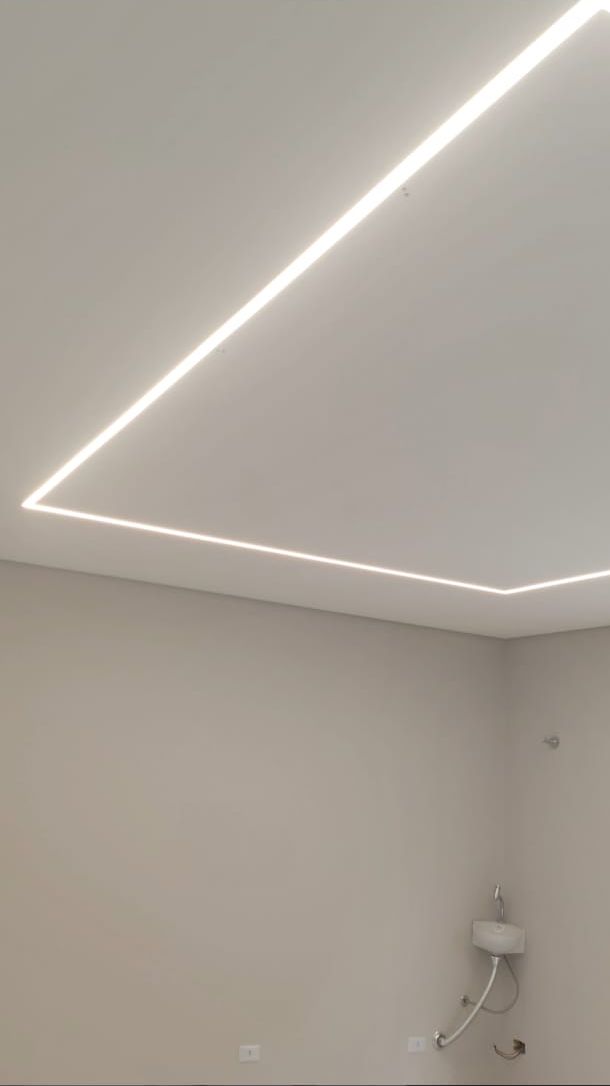 Perfil de LED embutido no teto de gesso formando uma linha de luz