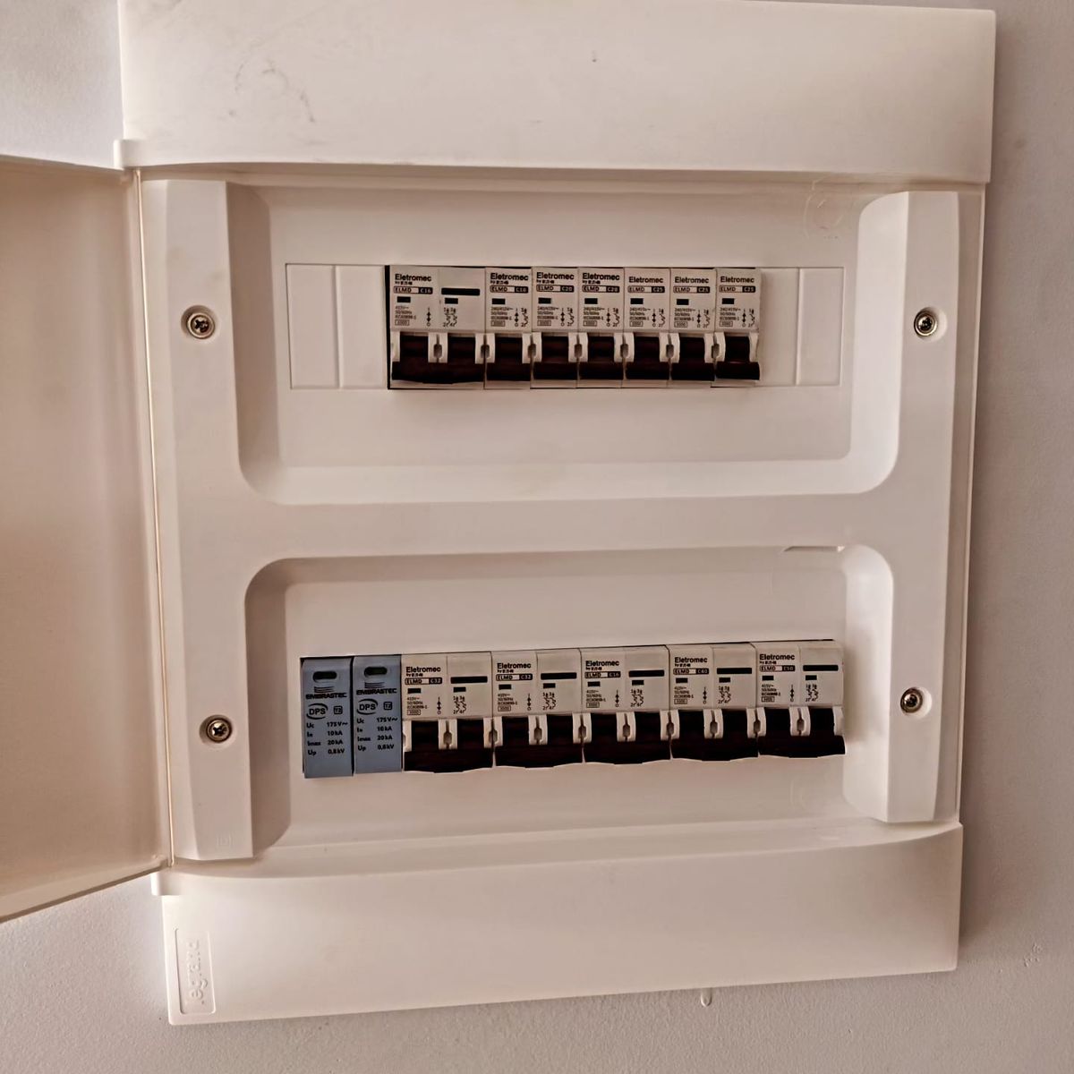 Quadro de distribuição de embutir finalizado, com tampa e disjuntores alinhados
