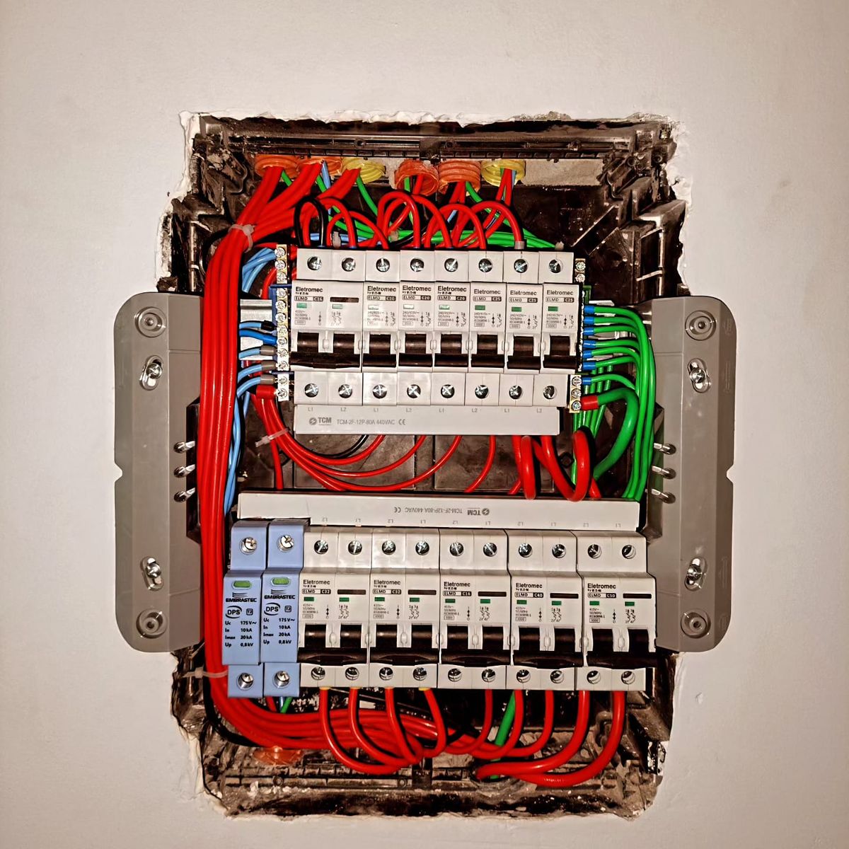 Quadro de distribuição em montagem, com disjuntores, DPS e cabos organizados por cor