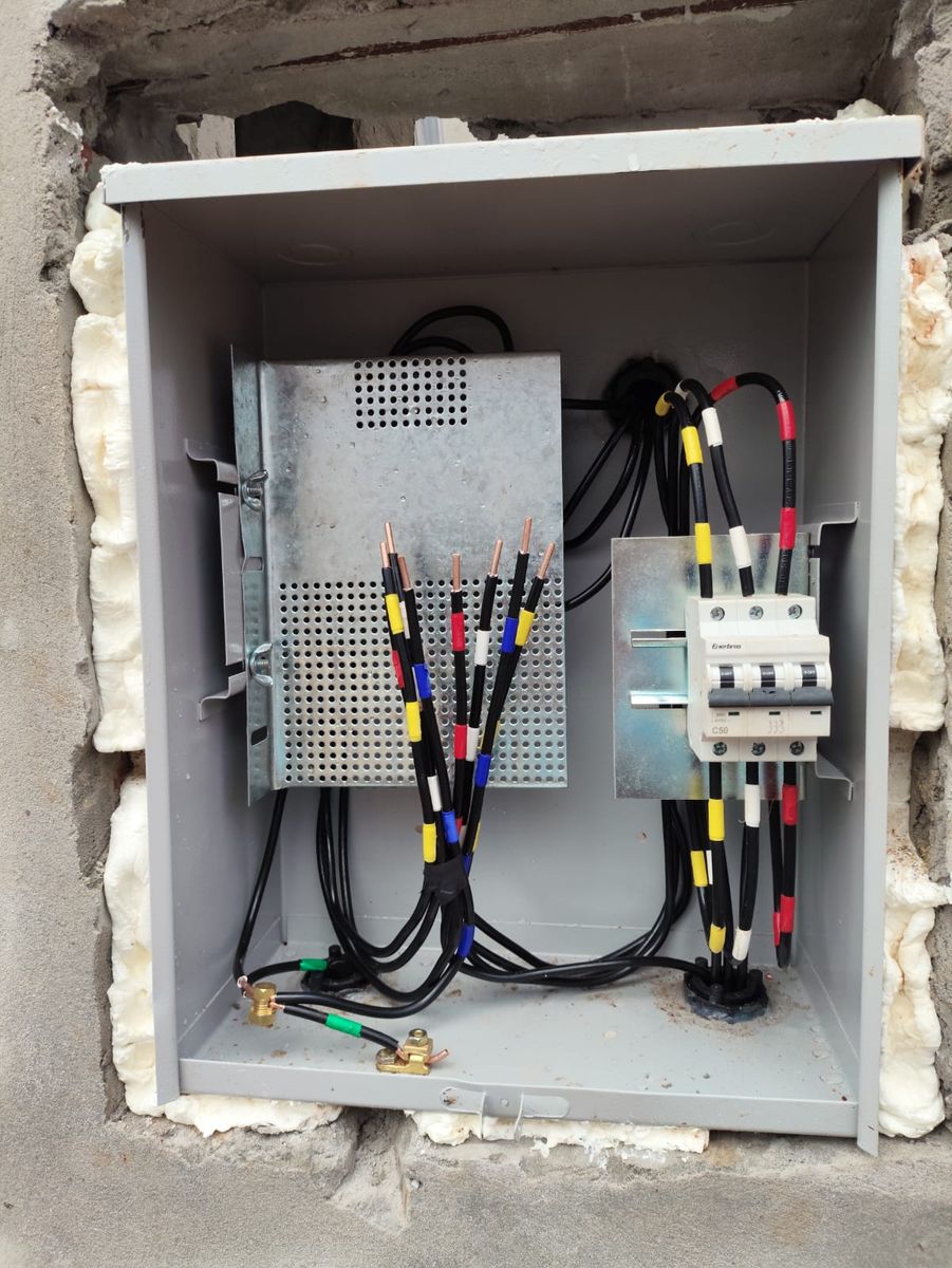 Quadro de comando com disjuntor tripolar e fios identificados por anilhas coloridas