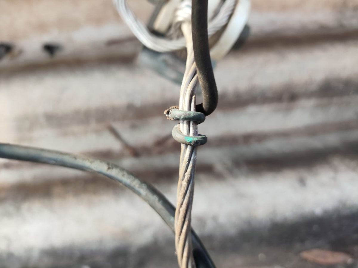 Emenda antiga de ramal feita com fio enrolado, sem conector